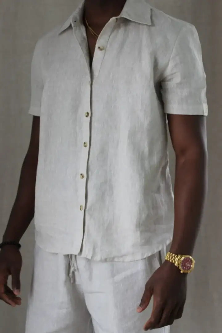 Man wearing a light-colored linen shirt and pants against a neutral background